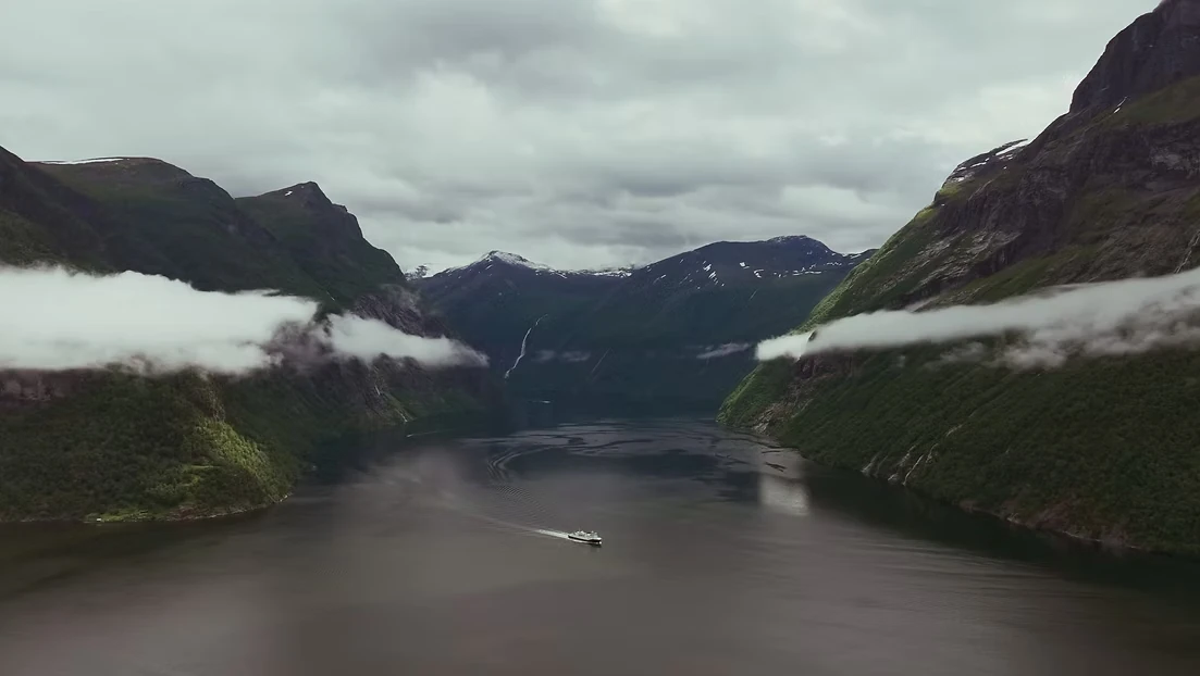 Fjord og snødekte fjell med en kartmarkør, fra filmen for Guide To Go.