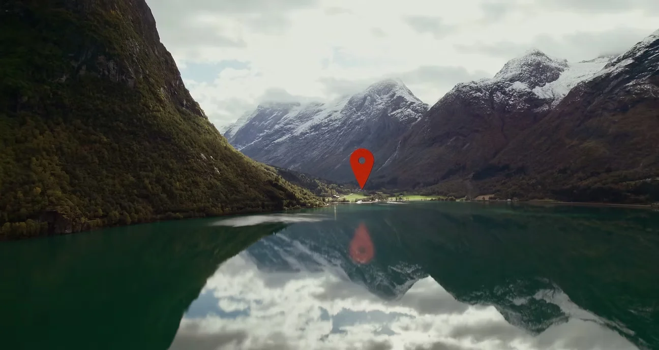Fjord og snødekte fjell med en kartmarkør, fra filmen for Guide To Go.